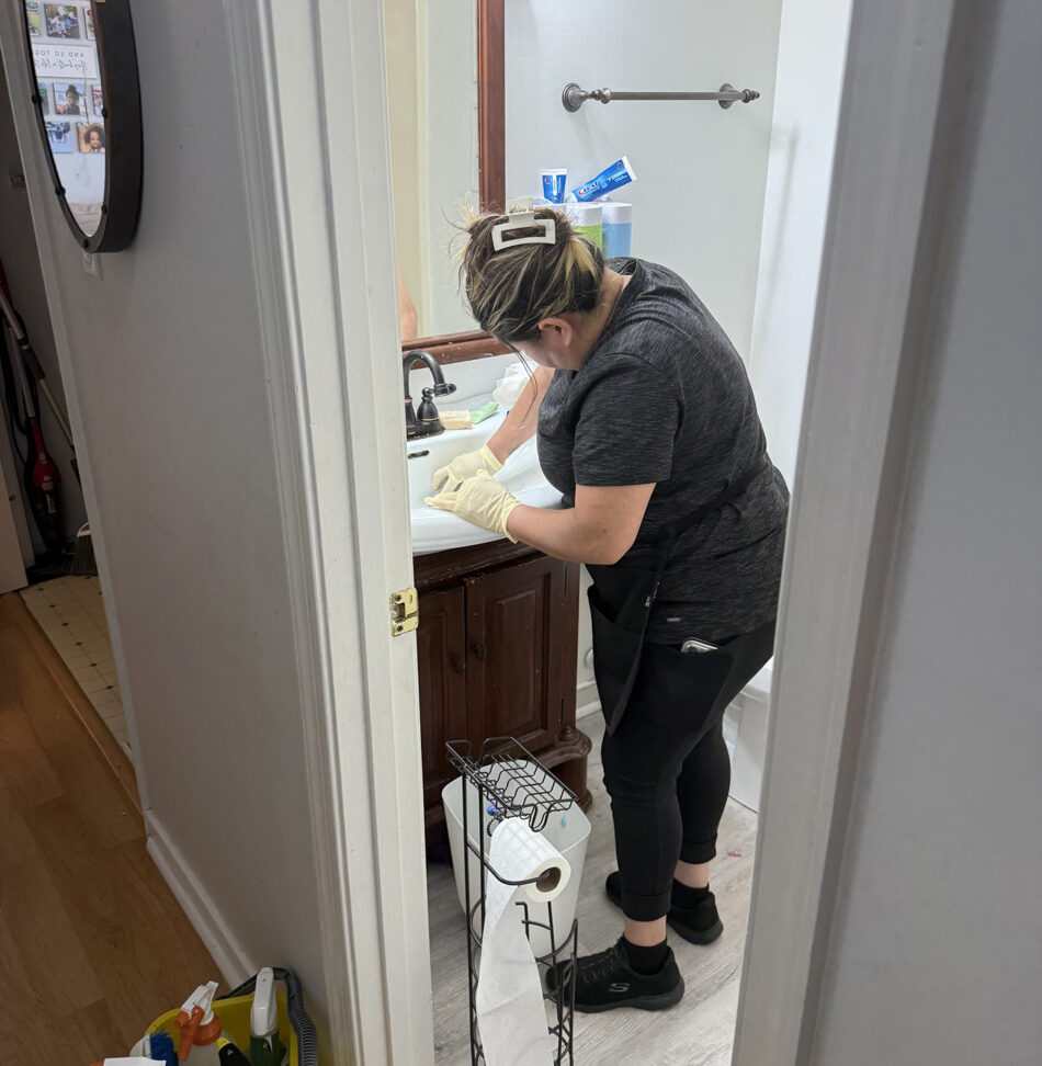 A Professional Edge Cleaning provider doing a deep clean in a bathroom.