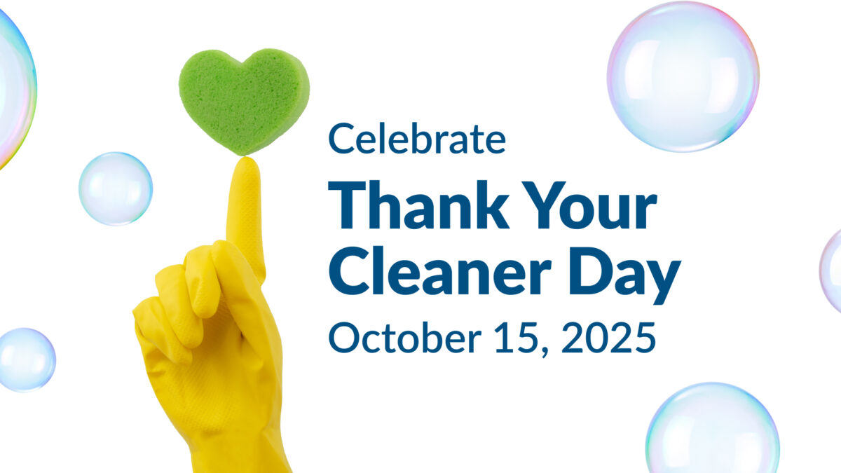 A yellow-gloved hand balancing a green heart-shaped sponge on one finger surrounded by floating soap bubbles, with the text “Celebrate Thank Your Cleaner Day, October 15, 2025.”